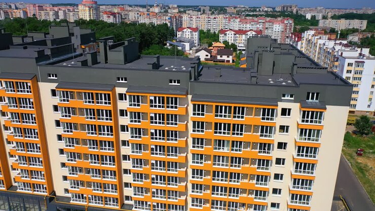 New city landmark. Modern apartment building on urban background. Colorful design of a multi-storey architecture. Aerial view.