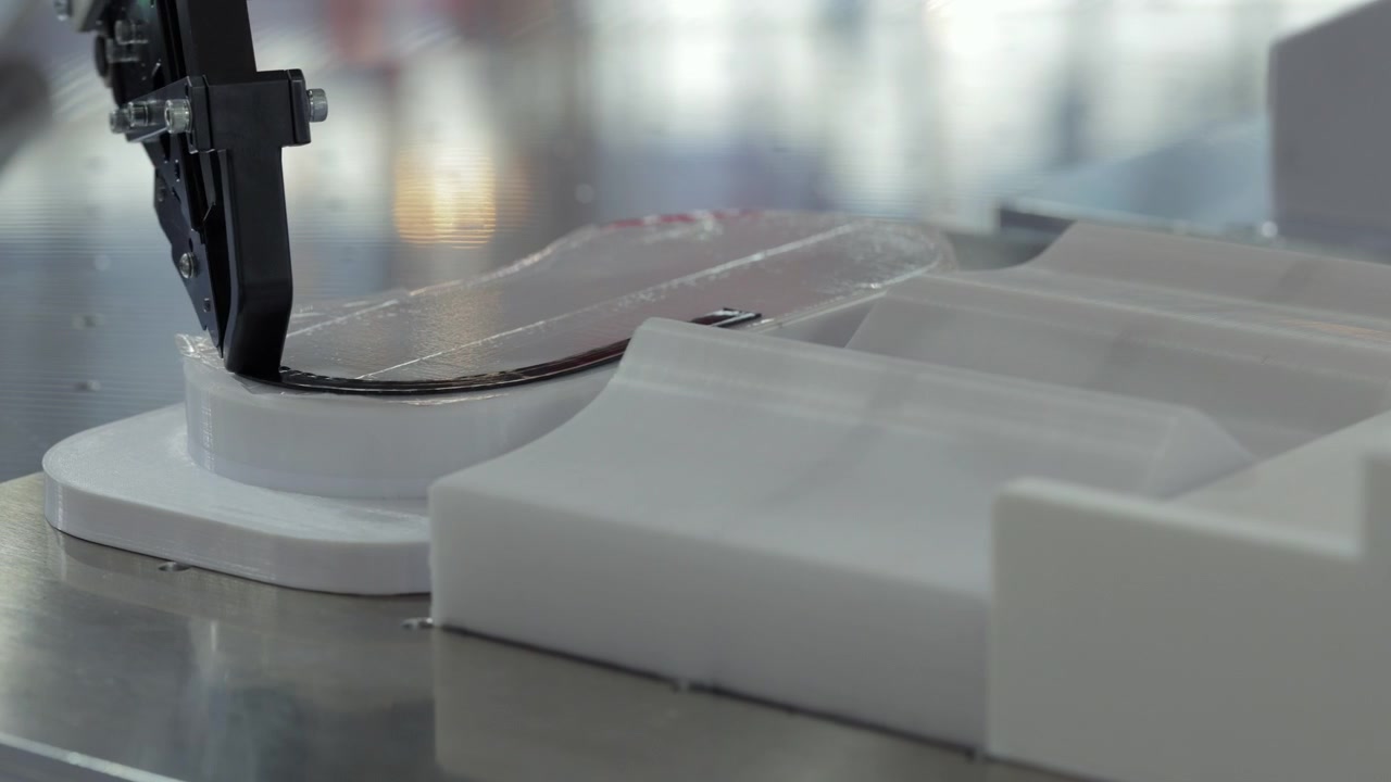 Stampante 3D industriale che estrude filamento nero su un prototipo bianco