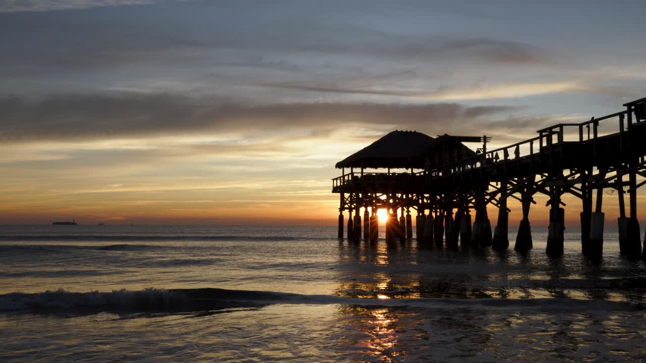 Sunrise over the Atlantic Ocean with the Cocoa Beach pier in silhouette