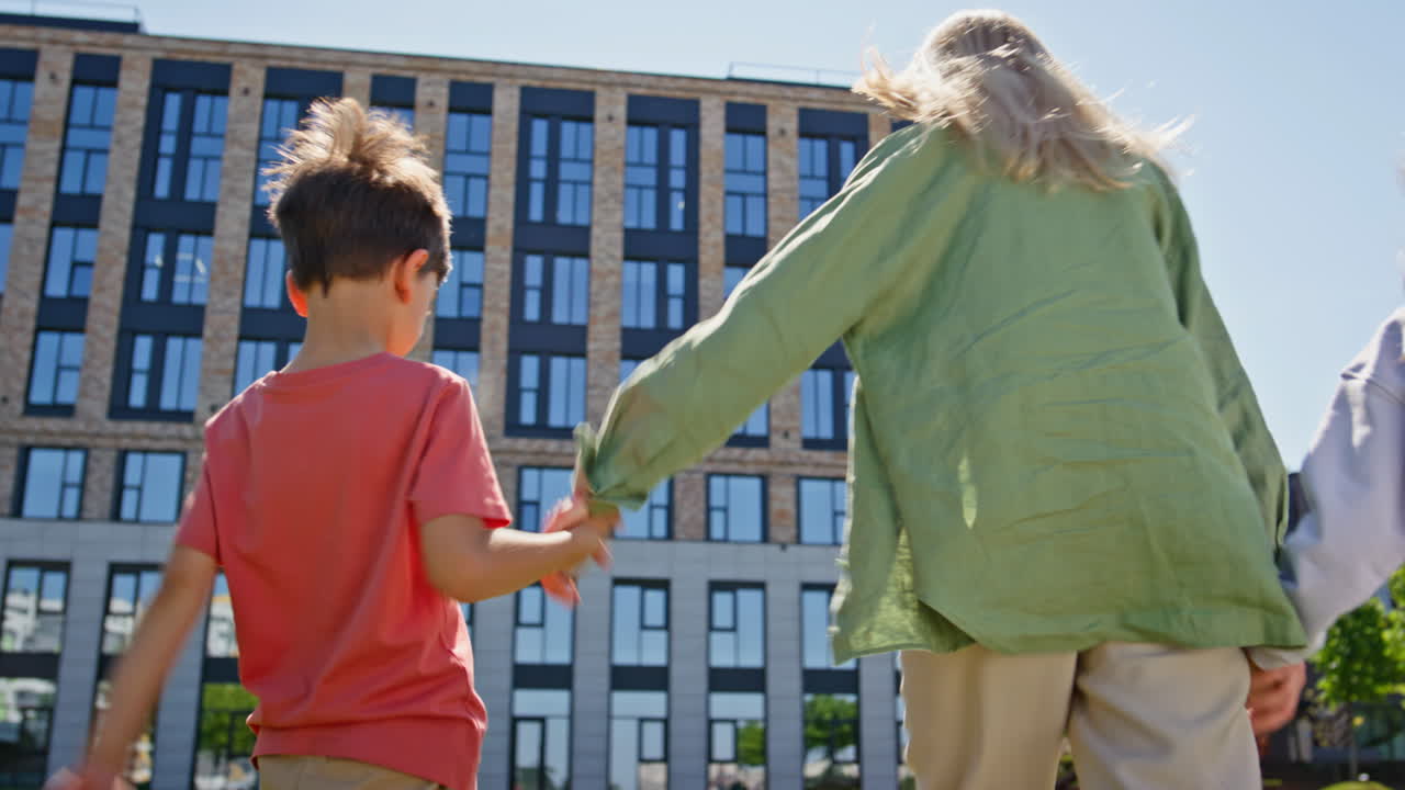 Carefree mother walking kids greenery neighbourhood strolling meadow rear view