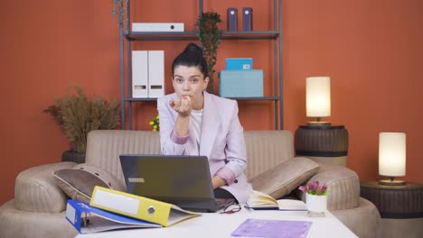 Mujer-Joven-Trabajadora-De-Oficina-En-Casa-Mordiéndose-Las-Uñas-Mirando-A-La-Cámara.