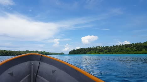 Motorboat-moving-fast-speed-over-placid,-calm-blue-ocean-with-remote-tropical-islands-in-the-Solomon-Islands