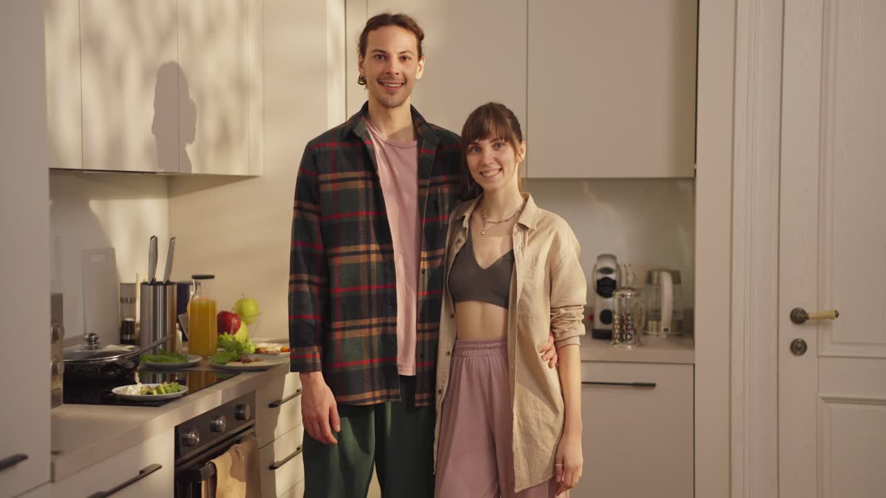 Coppia che posa nella propria cucina