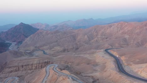 a road winds through the stunning barren eilat mountain range in israel