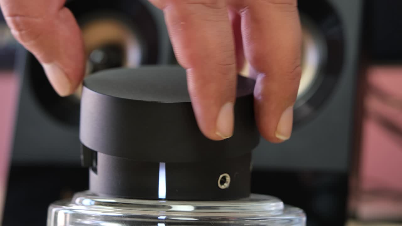 A man's hand mutes or unmutes the loudspeaker