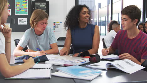 Lehrer-Studiert-Schulbücher-Im-Unterricht-Mit-High-School-Kindern