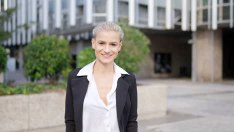 portrait of a smiling businesswoman with short hair in an urban setting