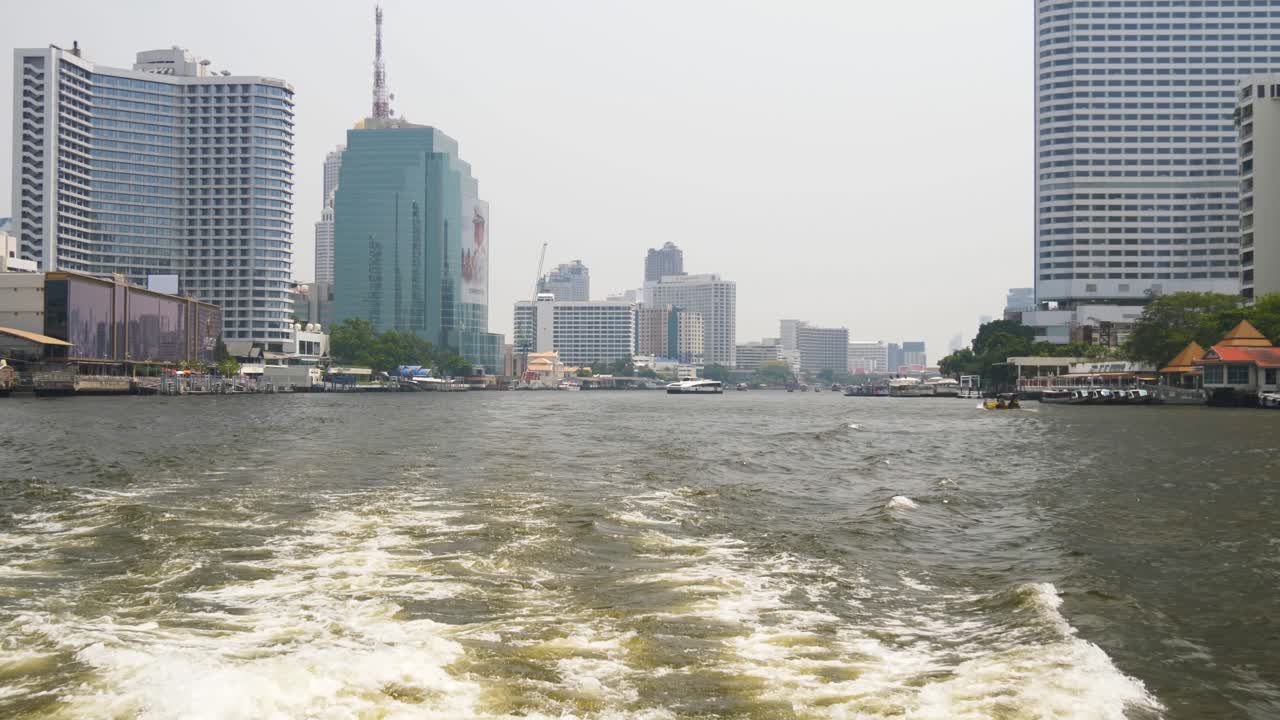 Waterfront City Skyline Along Chao Phraya River In Bangkok, Capital Of Thailand. POV Shot