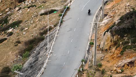 Driving-the-curvy-road-on-motorbike-going-kitesurfing-with-kiteboard-and-kite-strapped-on-to-the-bike