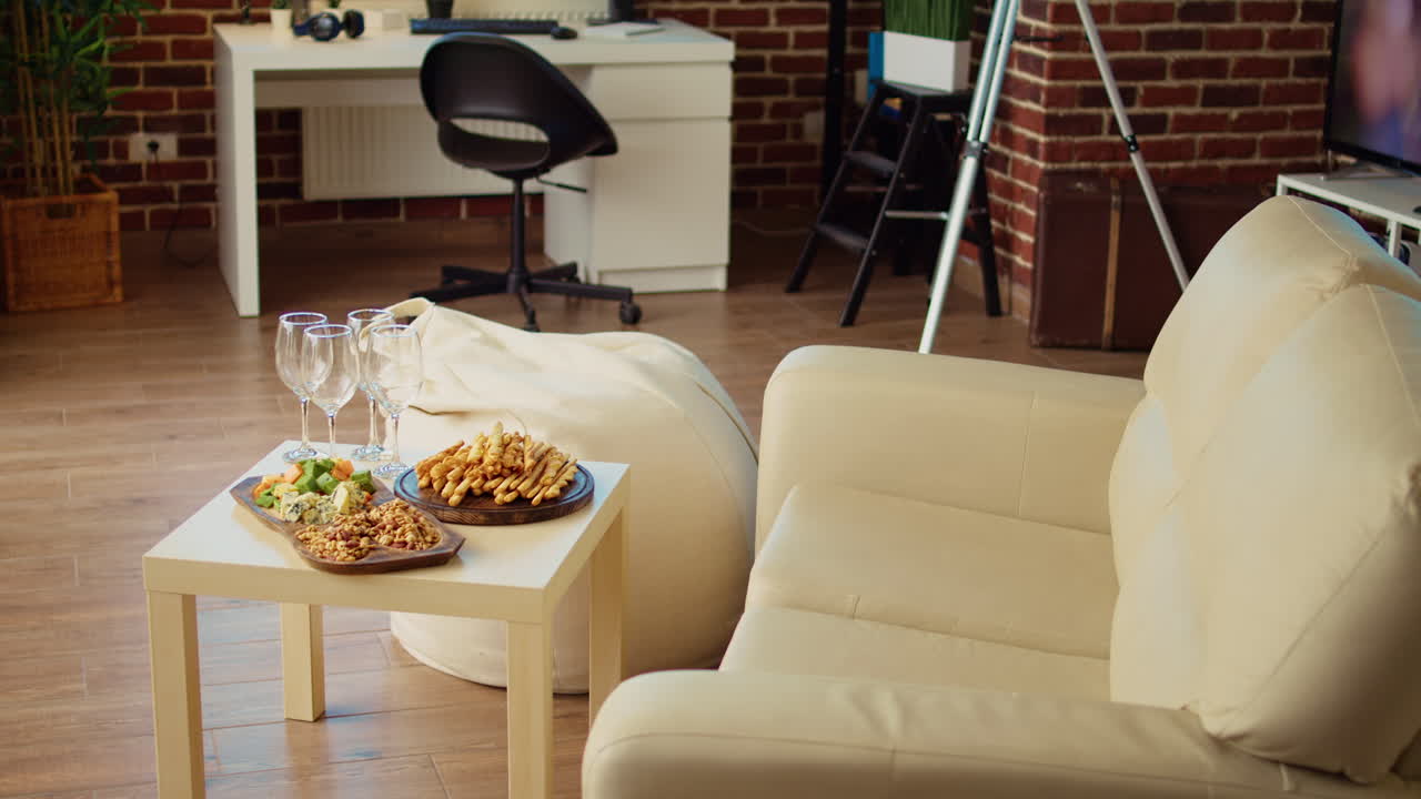 Empty stylish cozy apartment living room with crackers, peanuts and cheese on charcuterie board