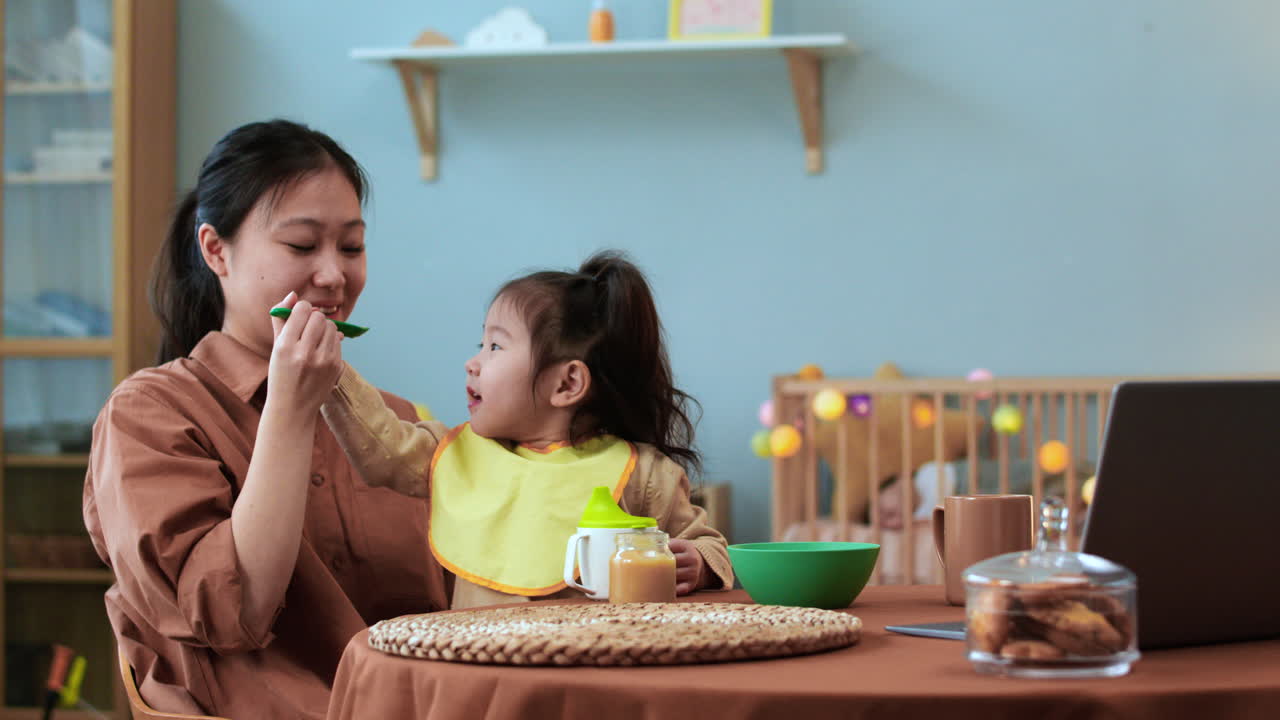 아기 와 함께 테이블 에 앉아 있는 아시아 여자