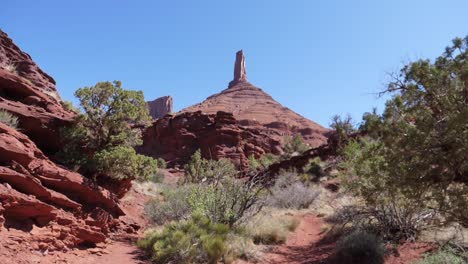 slo motion walk up to massive red rock structure statue tower in utah