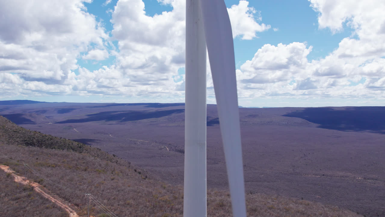 Aerial rising near wind turbine rotating, sunny day in countryside. Close up