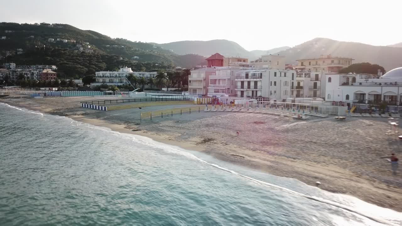 Drone aerial shot of the Mediterranean shore during a sunset. sandy beach, Genoa, Italy