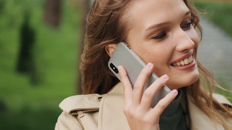 Studentessa caucasica che parla al telefono all'aperto.