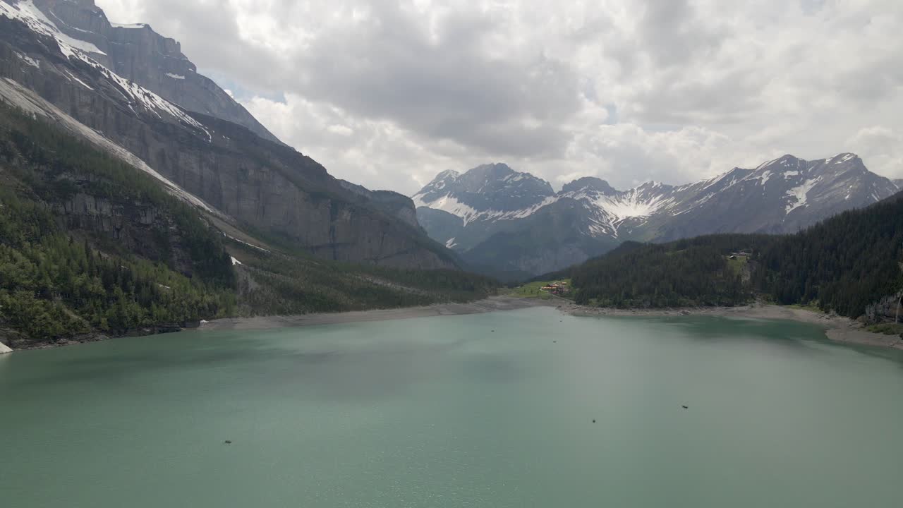 작은 보트가 있는 외스키네제 호수의 표면을 향해 내려가며 주변 산맥의 규모를 완전히 드러냅니다.