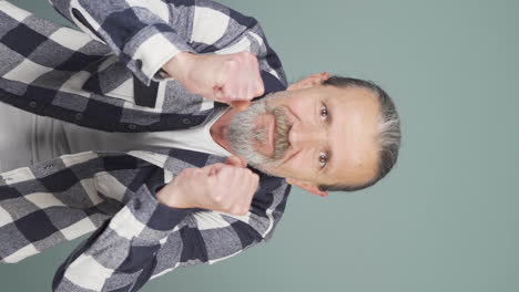 Vertical-video-of-Old-man-looking-at-camera-in-amazement.