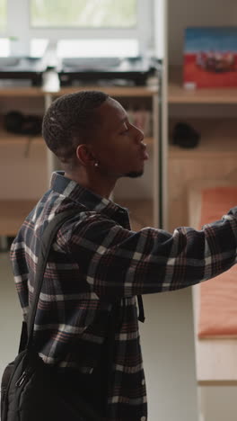 man browses for book on library shelf. dark-skinned student selecting literature for homework seen at university information center. guy perusing in bookstore