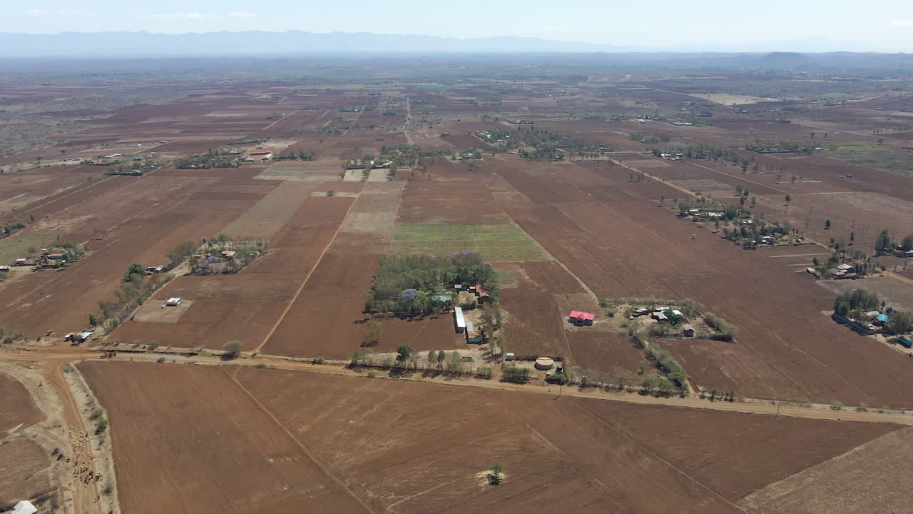 High angle pan of several houses in a rustic area in rural Kenya