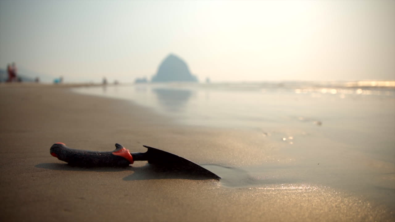 Close up of shovel on sandy beach. Canon beach smoke