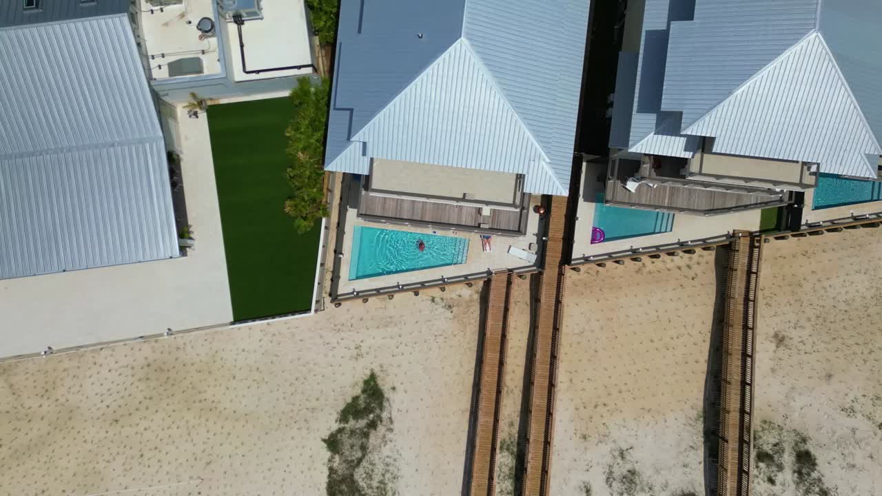 vista aérea de arriba hacia abajo del condominio y la piscina ubicada en orange beach, alabama