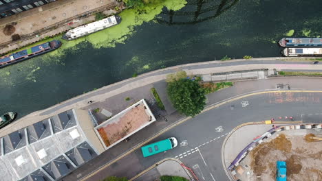 ariel view of regents canal en el este de londres con botes de canal, vehículo en una calle tranquila y ciclistas paseando