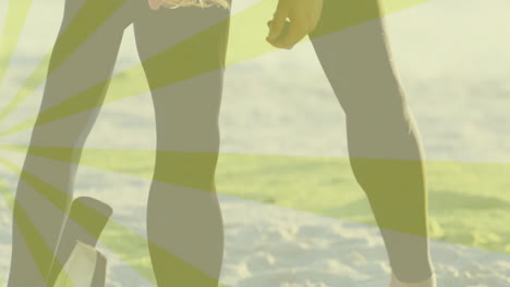 surfers standing on beach shore for travel marketing wearing wetsuit leggings showing radial stripe