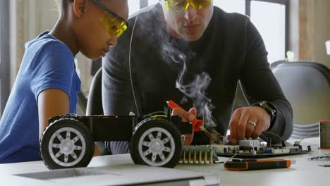 father and daughter using soldering iron on car 4k