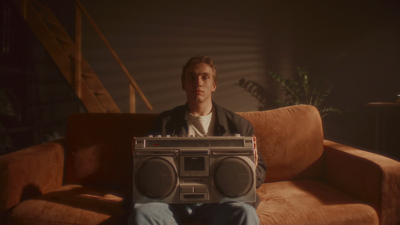 Portrait of Young Man Inserting Cassette Tape into Retro Boombox