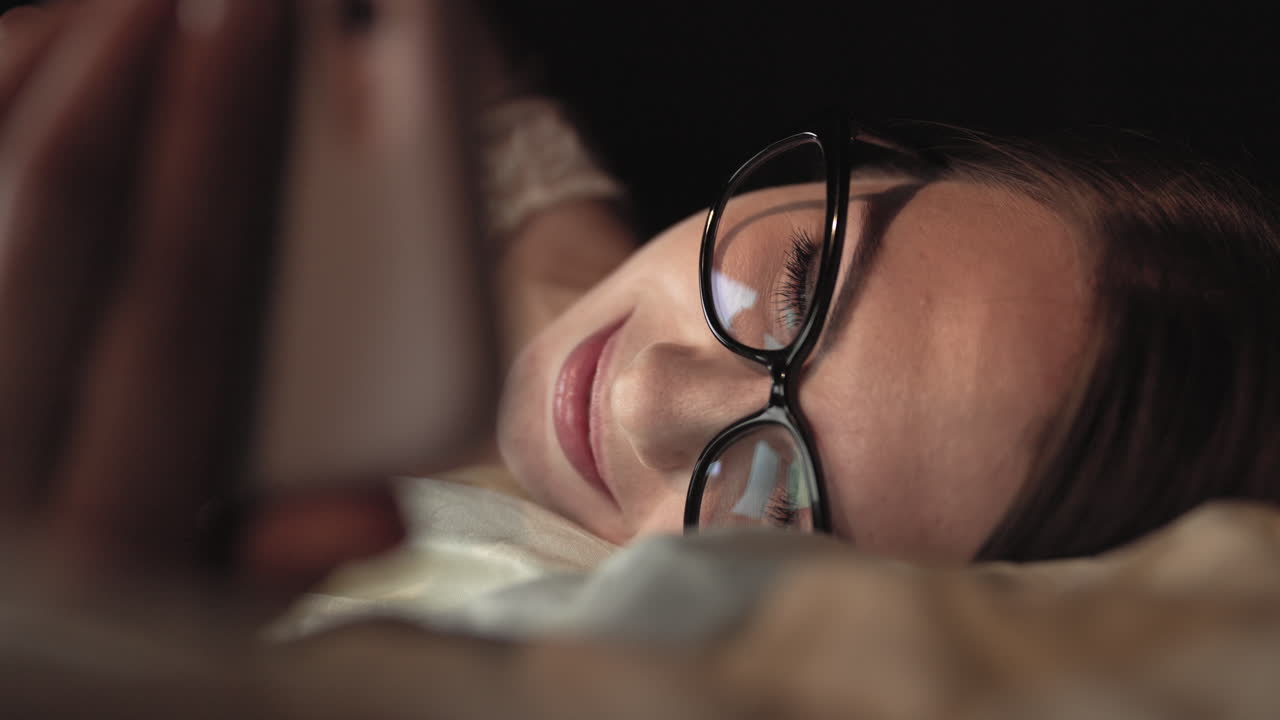 mujer usando el teléfono en la cama por la noche