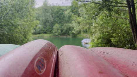 red boats canoes lie upside down on the shore of a lake