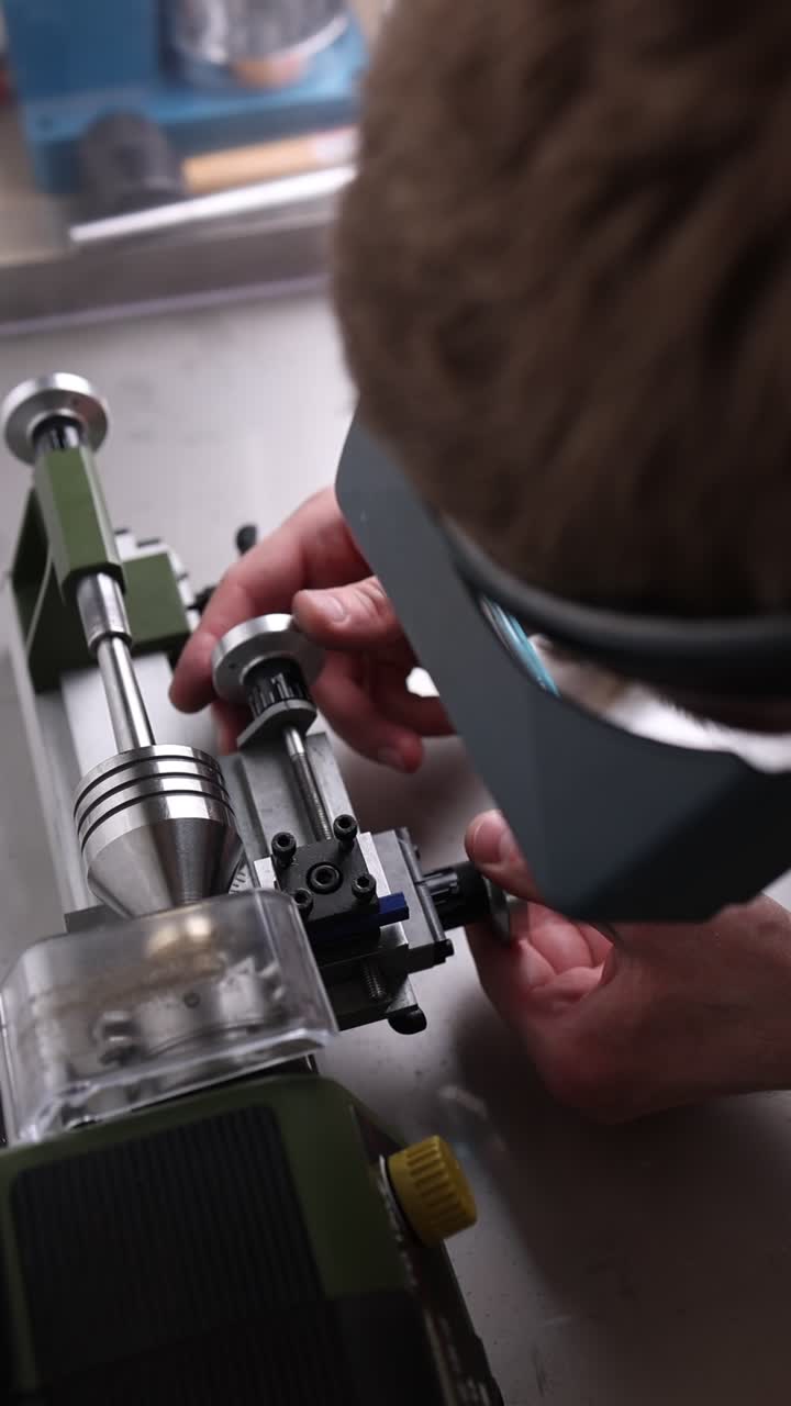 Close-up of Man Adjusting a Small Precision Lathe Machine
