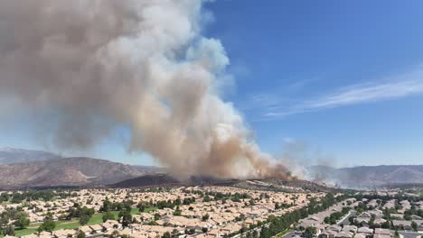 Großer-Waldbrand-In-San-Jancinto-Wildlife-Area-über-Der-Sun-Lakes-Gemeinde-In-Kalifornien,-Der-Feuer-In-Der-Nähe-Von-Häusern-Verbietet,-Statische-Luftaufnahme,-4K