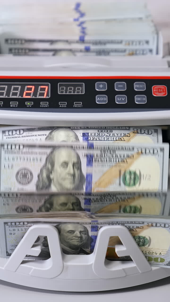 Counting operations in bank. Automatic mechanism counting hundred dollar banknotes. Electronic counting machine in bank. Vertical video