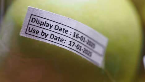 close-up of apple with display and use-by dates