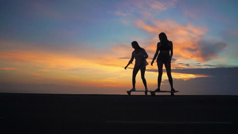 con una fascinante puesta de sol, dos amigos disfrutan de skateboarding en cámara lenta en una carretera, rodeados de montañas y un hermoso cielo. su atuendo incluye pantalones cortos
