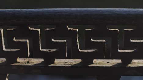 Metal-old-fence-by-the-river-with-infinite-shape-ornament-and-moody-sharp-contrast,-deep-blue-water-in-the-background