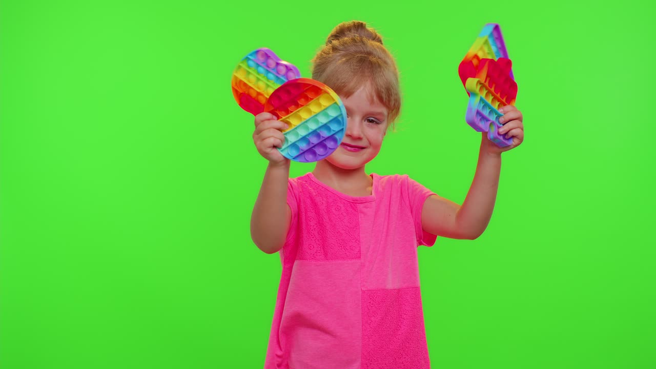 Niña escondida detrás de muchos juguetes sensoriales antiestrés pop it, juego de moda de burbujas blandas, antiestrés