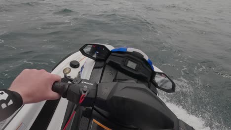 pov shot of a jet skier doing high speeds across a choppy ocean catching waves