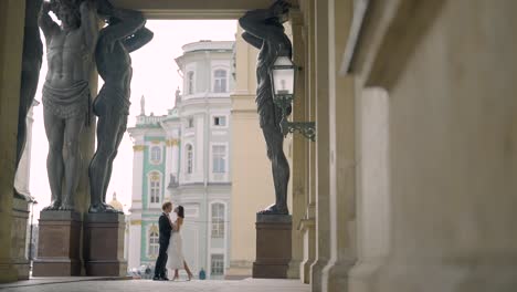 couple in love posing in front of the ancient statues