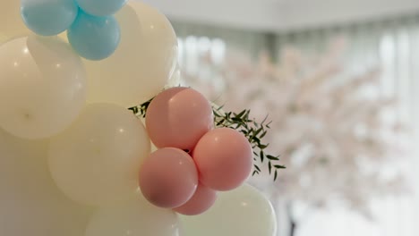 soft pastel balloons in pink, cream, and blue with greenery accent for a festive indoor setup