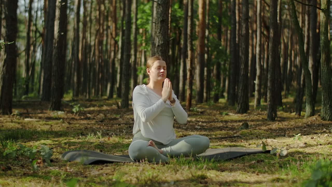 Woman practicing yoga and meditation in a peaceful forest setting