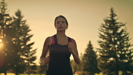 Young-woman-runner-running-in-park-at-sunset.-Fitness-woman-jogging-in-park