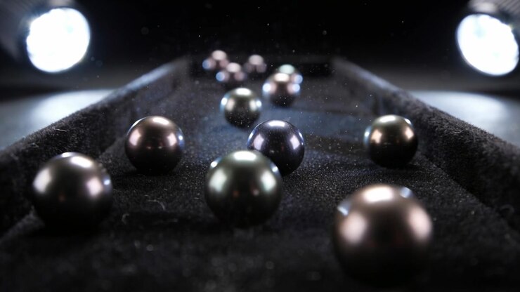 Rolling metal spheres down felt tray in studio new spheres colliding and kicking dust under lights