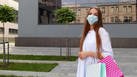 Teenager-girl-with-multicolor-shopping-bags-wearing-protect-mask.-Black-Friday-during-coronavirus