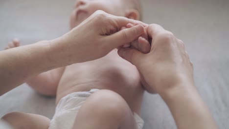 las manos de un pediatra profesional sostienen los dedos de un bebé