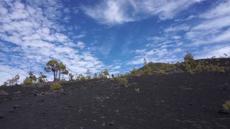 A-hiker-in-the-distant-hikes-up-a-volcano-beneath-a-beautiful-cloudy-sky