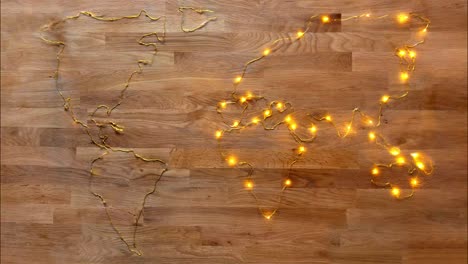 animation of the world map made with golden wire lights that gradually light up on a rustic wooden background. can be used for topics suchs as electricity, christmas, night, party,...