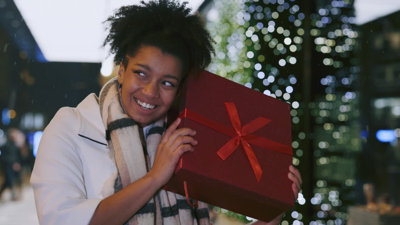 mujer sosteniendo un regalo de navidad
