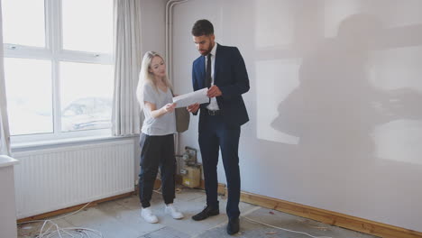 female first time buyer looking at house survey with realtor